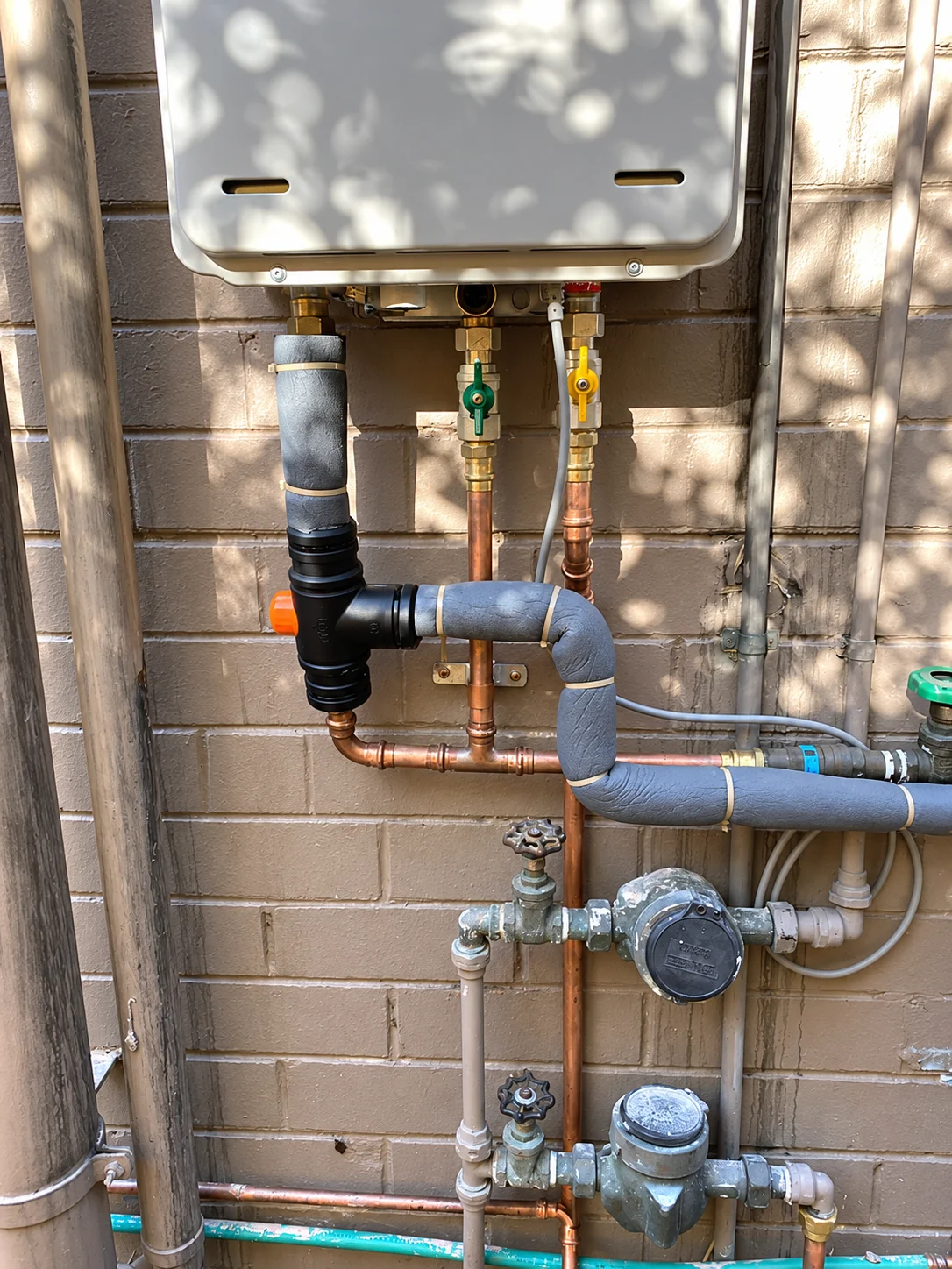 Exposed hot water unit connections and pipework.